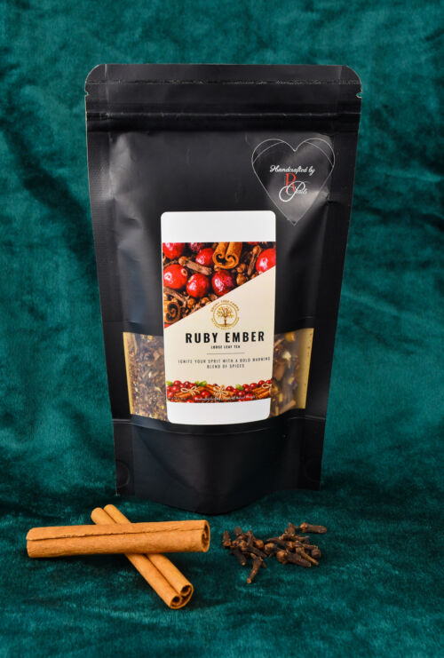 A picture of the custom blend two ounce loose leaf tea. There is a small plate in front of the product with cloves and cinnamon on display