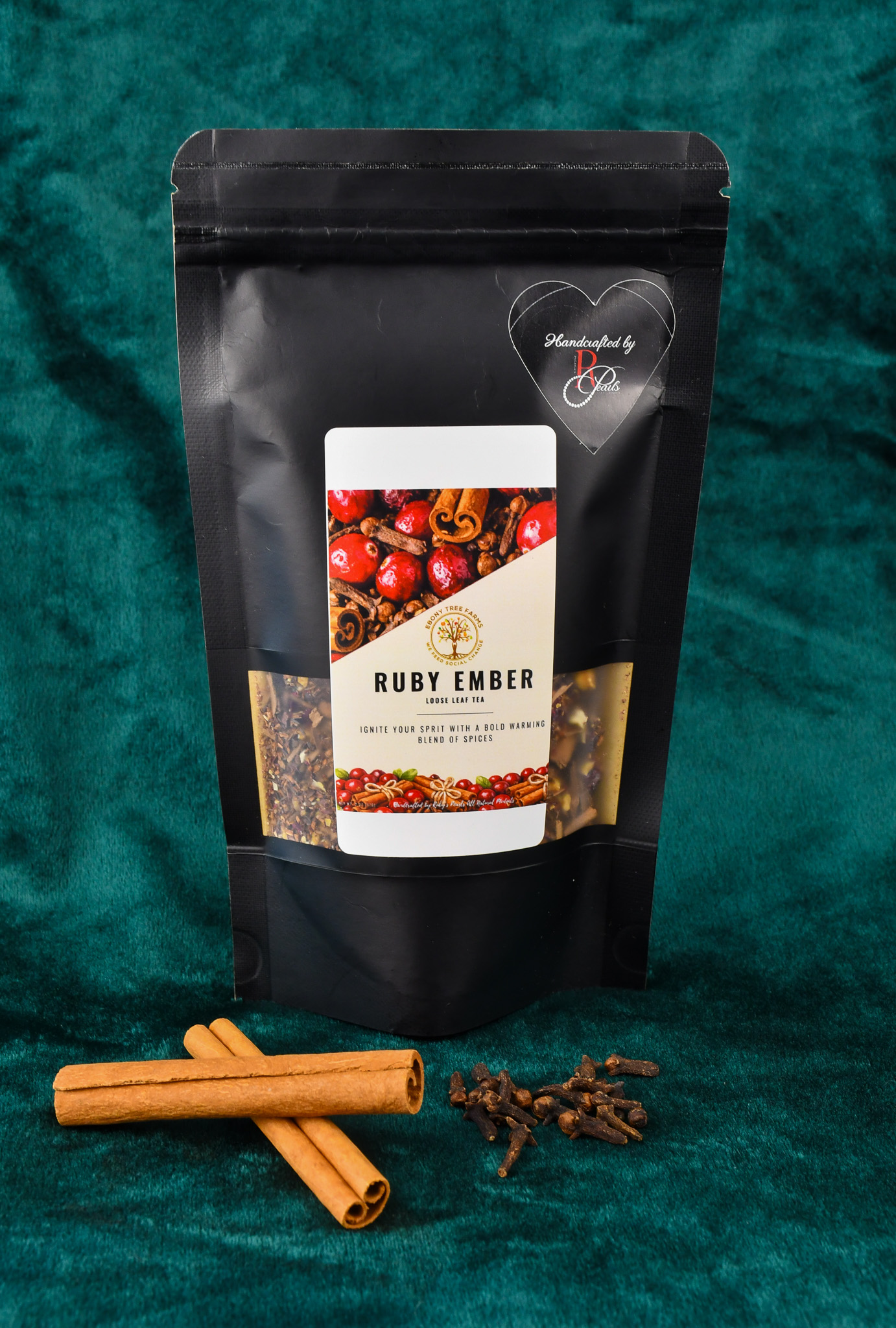 A picture of the custom blend two ounce loose leaf tea. There is a small plate in front of the product with cloves and cinnamon on display